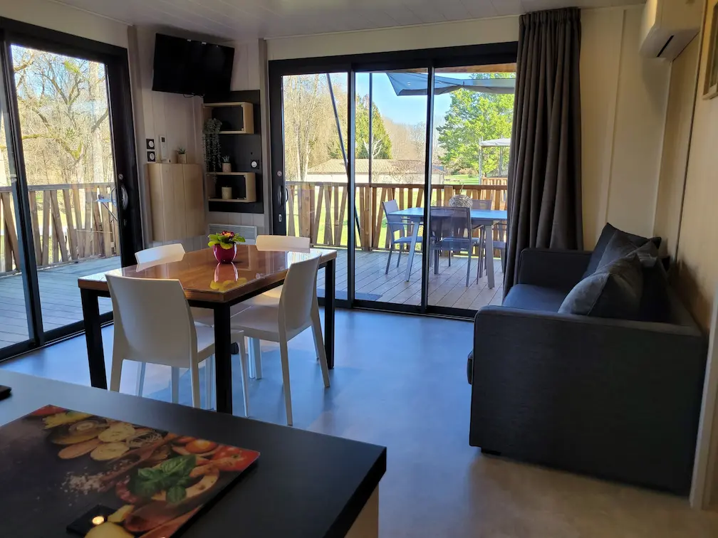 Salon confortable avec télévision et canapé dans le gîte